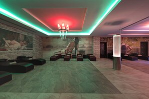 A lobby with a modern design, featuring a large seating area with sofas and a central pillar. - Alan Xafira Deluxe Resort & Spa (Alanya)