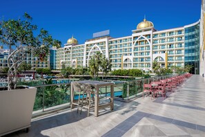 Ein Hotel mit Pool, Außenbereich und einem großflächigen Gebäude mit mehreren Stockwerken und Balkonen.