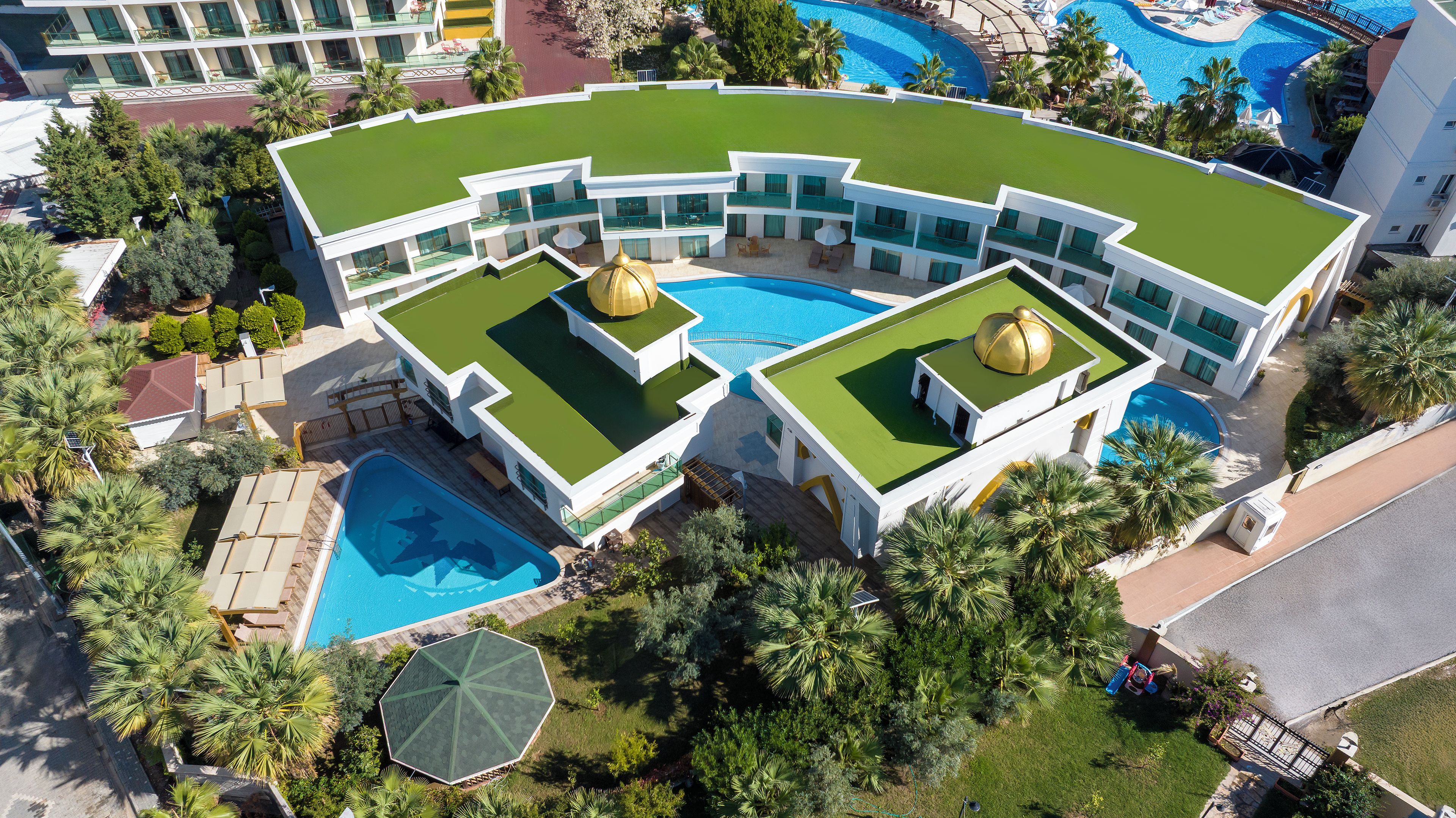 Ein modernes Hotel mit großem Pool, mehreren Balkonen und üppiger Bepflanzung.