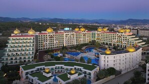 Un hotel con diversi piani, una piscina e cupole dorate sul tetto.