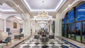A spacious lobby with a checkered floor, elegant chandeliers, and a large seating area. - Alan Xafira Deluxe Resort & Spa (Alanya)