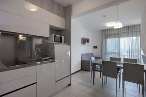 Appartement, balkon | Privékeuken | Een minikoelkast, een microgolfoven, een kookplaat, een kinderstoel