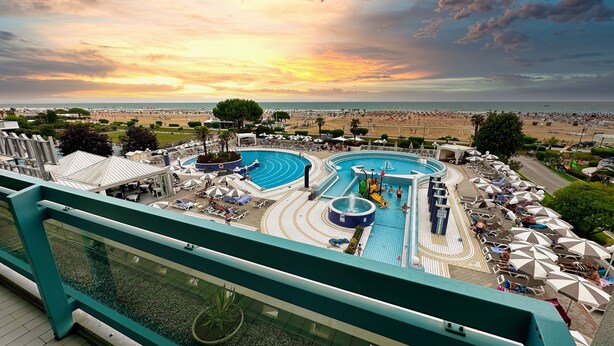 Een resort met meerdere zwembaden, ligbedden en parasols.