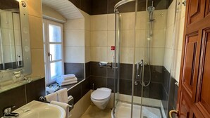 Une salle de bain avec une douche à parois de verre, un lavabo, des toilettes et un miroir.