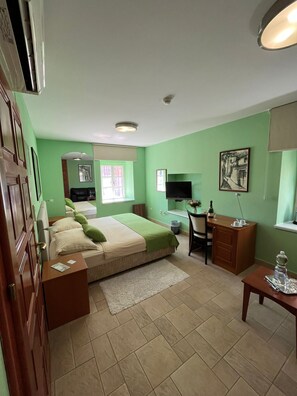 Una habitación con cama, escritorio, silla y televisor.