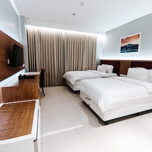 A hotel room with a bed, a desk, and a TV. - Hotel Prima Cirebon (North Cirebon)