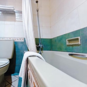 A bathroom with a bathtub, toilet, and shower. - Hotel Prima Cirebon (North Cirebon)