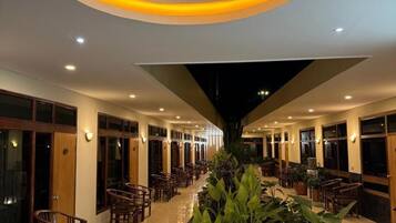 A hotel lobby with a central seating area, a water feature, and a circular light fixture.