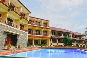 A hotel with multiple balconies, a swimming pool, and a clear sky. - Sanggabuana Puncak Convention & Resort (Pacet)