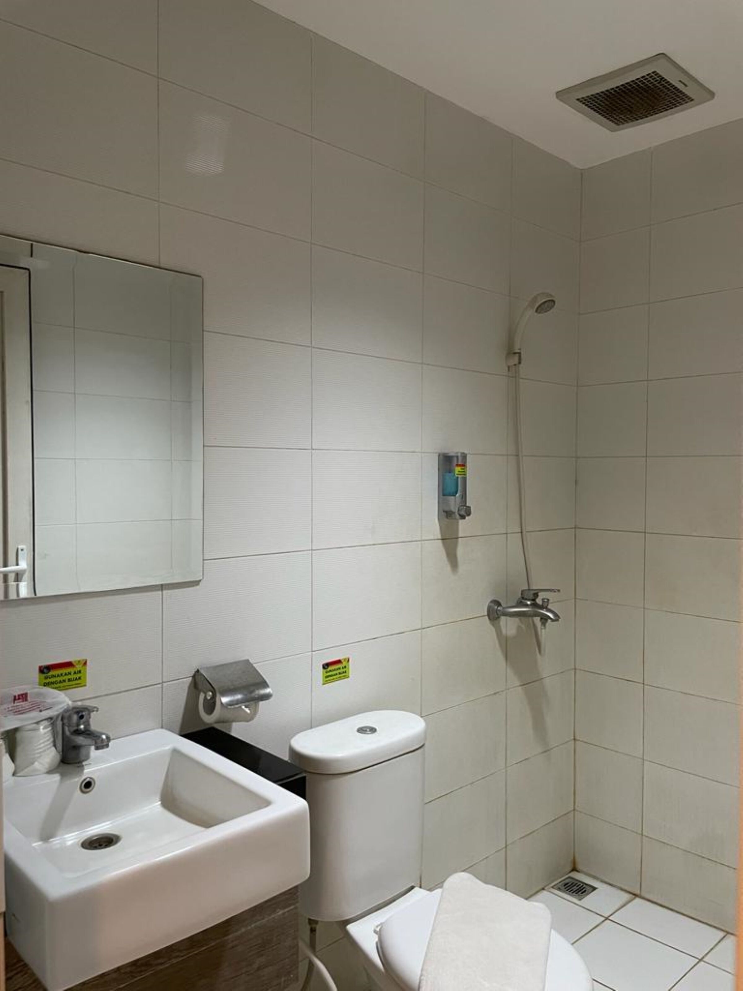 Un baño pequeño y limpio con lavamanos, inodoro y ducha.