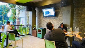 Un café moderne avec un mur en pierre et un téléviseur à écran plat fixé au mur.