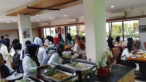 A cafeteria with multiple tables and people dining. - Hotel Grand Karawang Indah (Karawang)