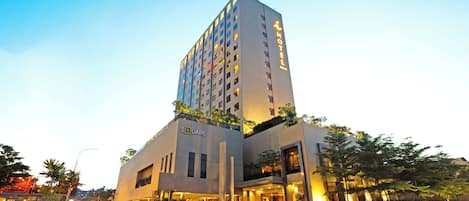 A modern hotel with a prominent 'HOTEL' sign on the facade, a 'SQUARE' logo, and a well-lit entrance.