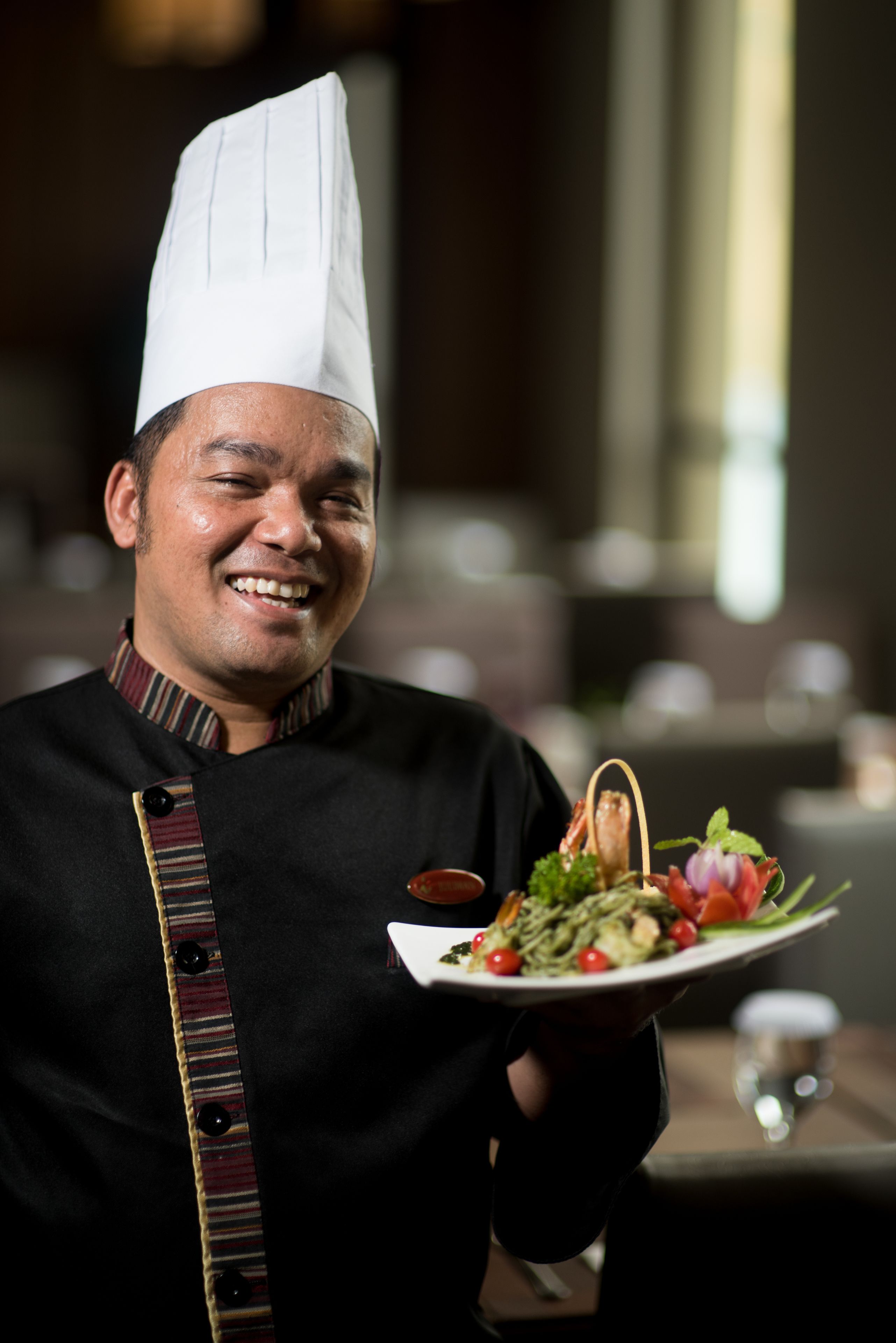 A chef holding a plate of food.