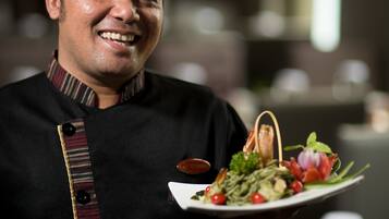 A chef holding a plate of food.