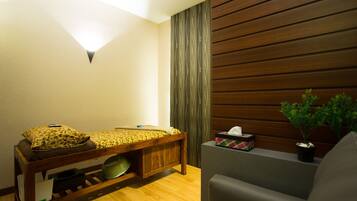 A room with a wooden bench, a small table, a potted plant, and a wall-mounted light fixture.