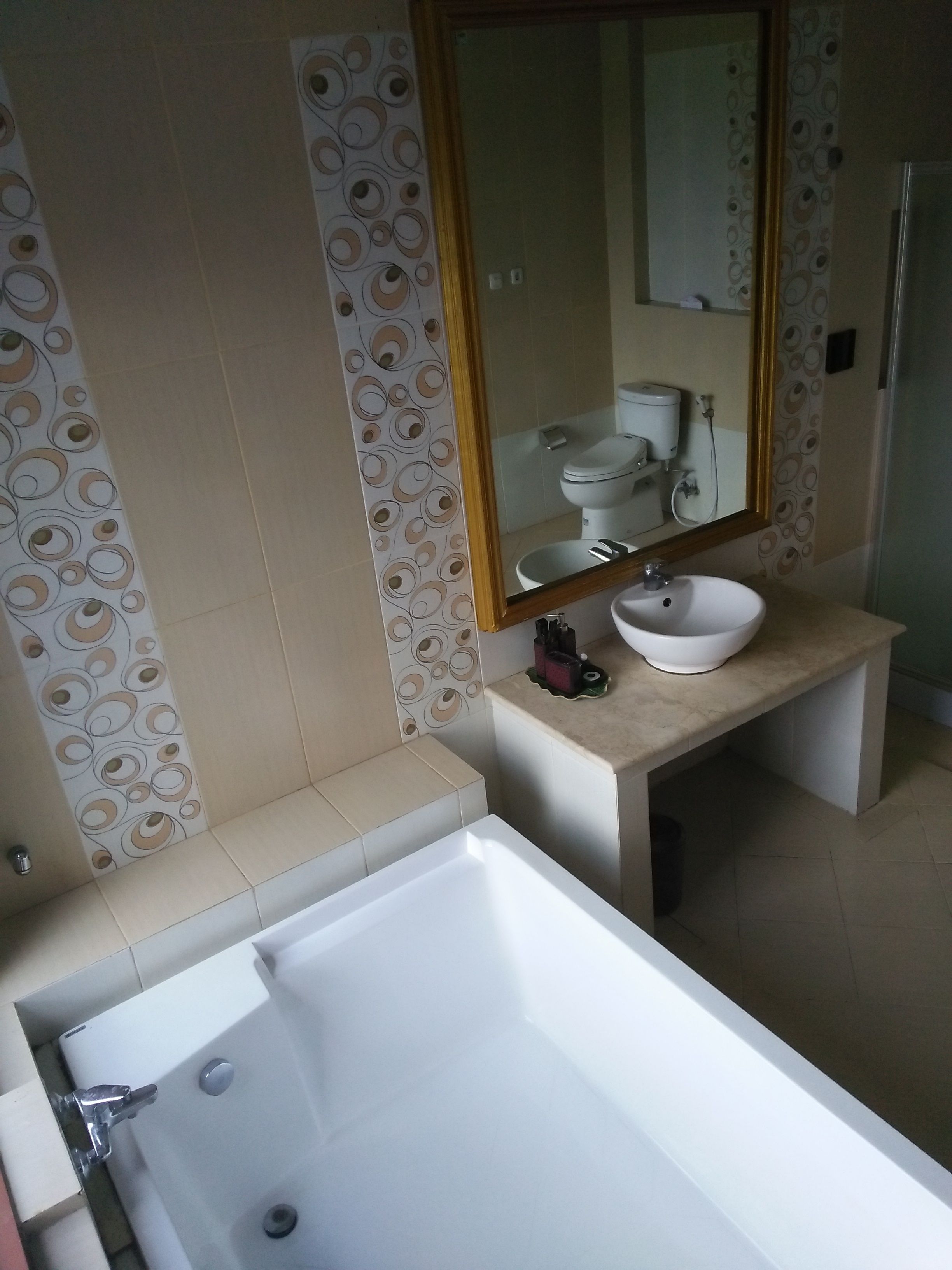 Un baño con bañera, lavamanos y espejo.