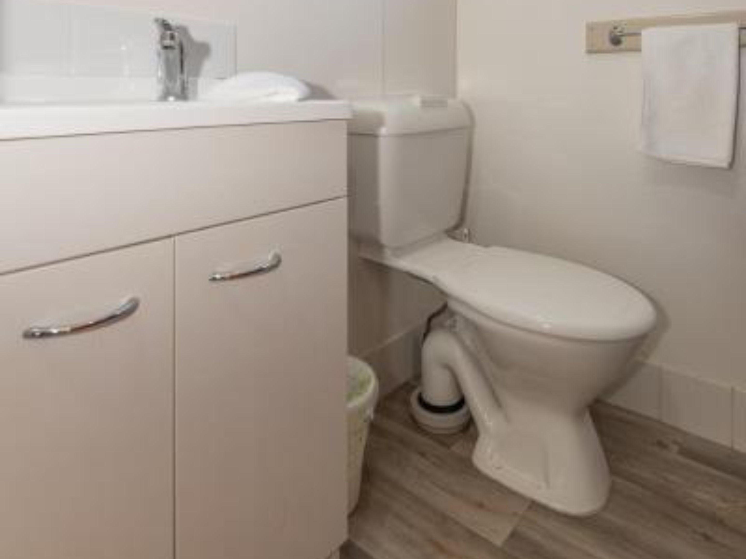 Ein Badezimmer mit Toilette, Waschbecken und Schrank.