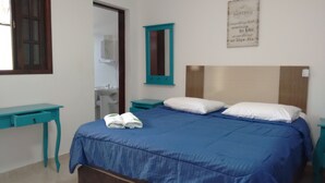 A bedroom with a bed, a nightstand, a desk, a mirror, and a wall with a motivational quote. - Pousada Acqua Infinity (Bertioga)