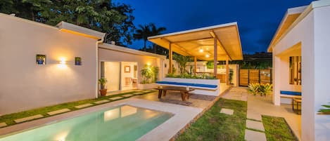 Una piscina al aire libre, sillones reclinables de piscina