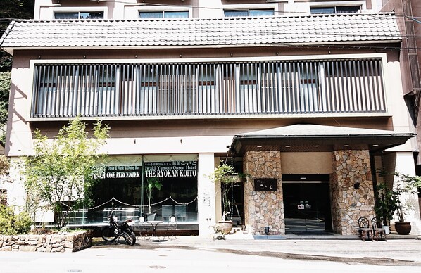 A hotel with a stone facade, a covered entrance, and a sign reading "Ryokan Kaito". - Koito Ryokan (Iwaki)