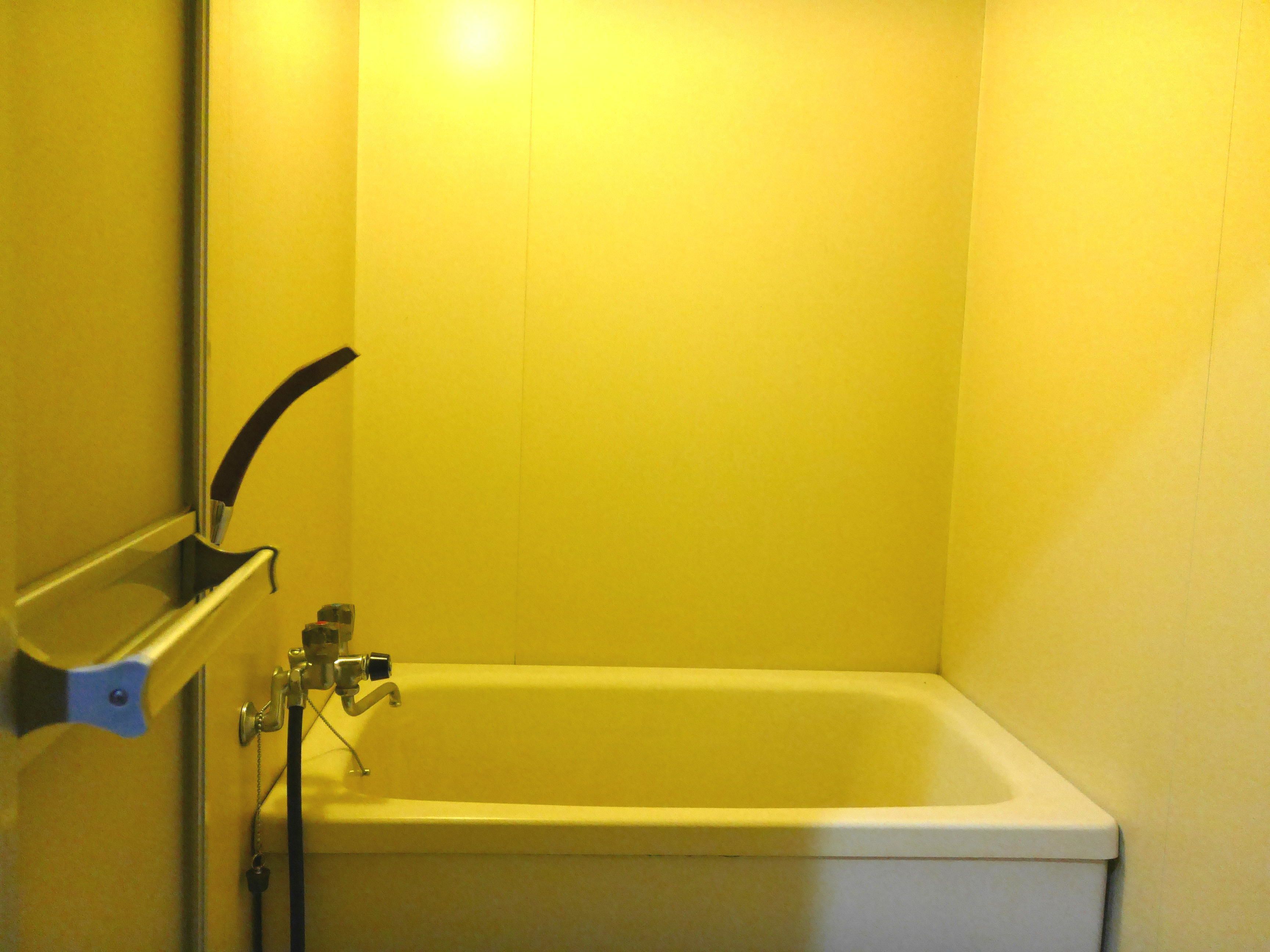 Un baño pequeño y cerrado con bañera, zona de ducha y retrete.