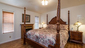 A four-poster bed with floral bedding, wooden nightstands, and a fireplace. - Inside Yosemite Lower Cascades (Yosemite National Park)