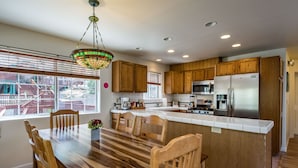 A modern kitchen with wooden cabinets, a large island, and stainless steel appliances. - Inside Yosemite Lower Cascades (Yosemite National Park)