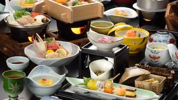 A variety of Japanese dishes and traditional tea set on a tray.