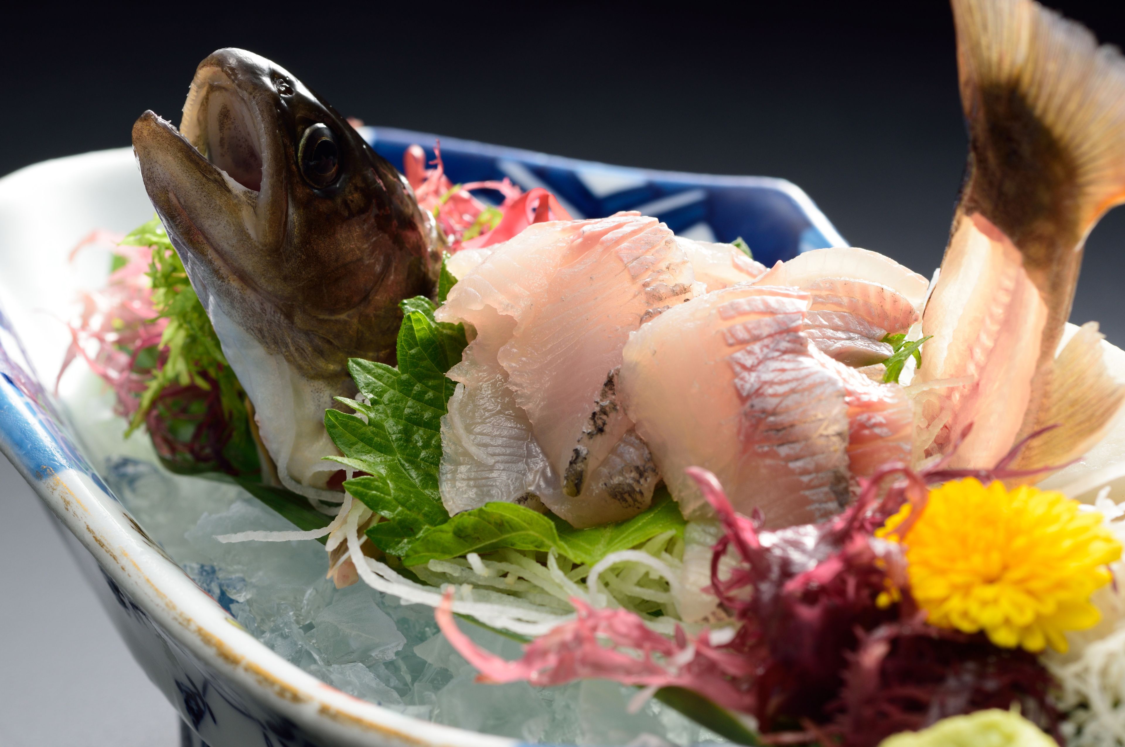 A seafood dish with various types of fish and garnishes.