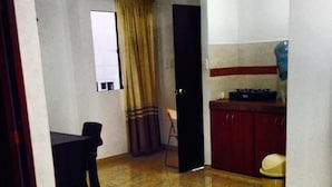A narrow hallway with a dining area, a kitchen with a water dispenser, and a door leading to another room. - Posada Infitness 2 (San Andrés)