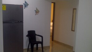 A kitchen with a refrigerator and a chair. - Posada Infitness 2 (San Andrés)