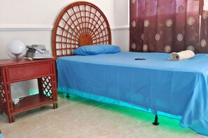 A room with a bed, a nightstand, and a lamp. - Sweet Sand Hostel (Isla de San Andres)