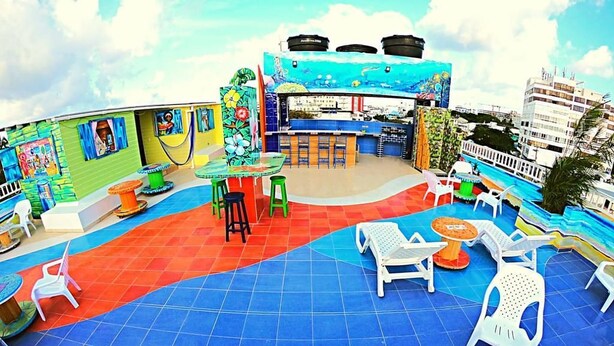 An outdoor patio area with a pool, seating arrangements, and a bar. - La Posada de Lulu (San Andrés)