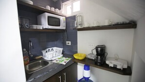 A compact kitchen with a microwave, coffee maker, and a sink. - Hospedaje Solymar I Sarie Bay (San Andrés)