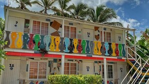 A multi-story building with numbered rooms, a colorful facade, and a staircase leading to the upper floors. - Posada Donde Pilo Avila (San Andrés)