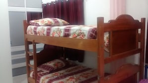 A bunk bed with floral bedding and a wooden headboard. - Posada Estrella del Mar (Isla de San Andres)