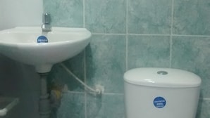 A bathroom with a white sink, a toilet, and a mirror above the sink. - Posada Estrella del Mar (Isla de San Andres)
