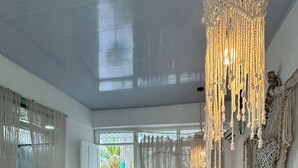 Une chambre spacieuse avec un grand lit, des décorations murales en macramé et une vue sur la verdure.
