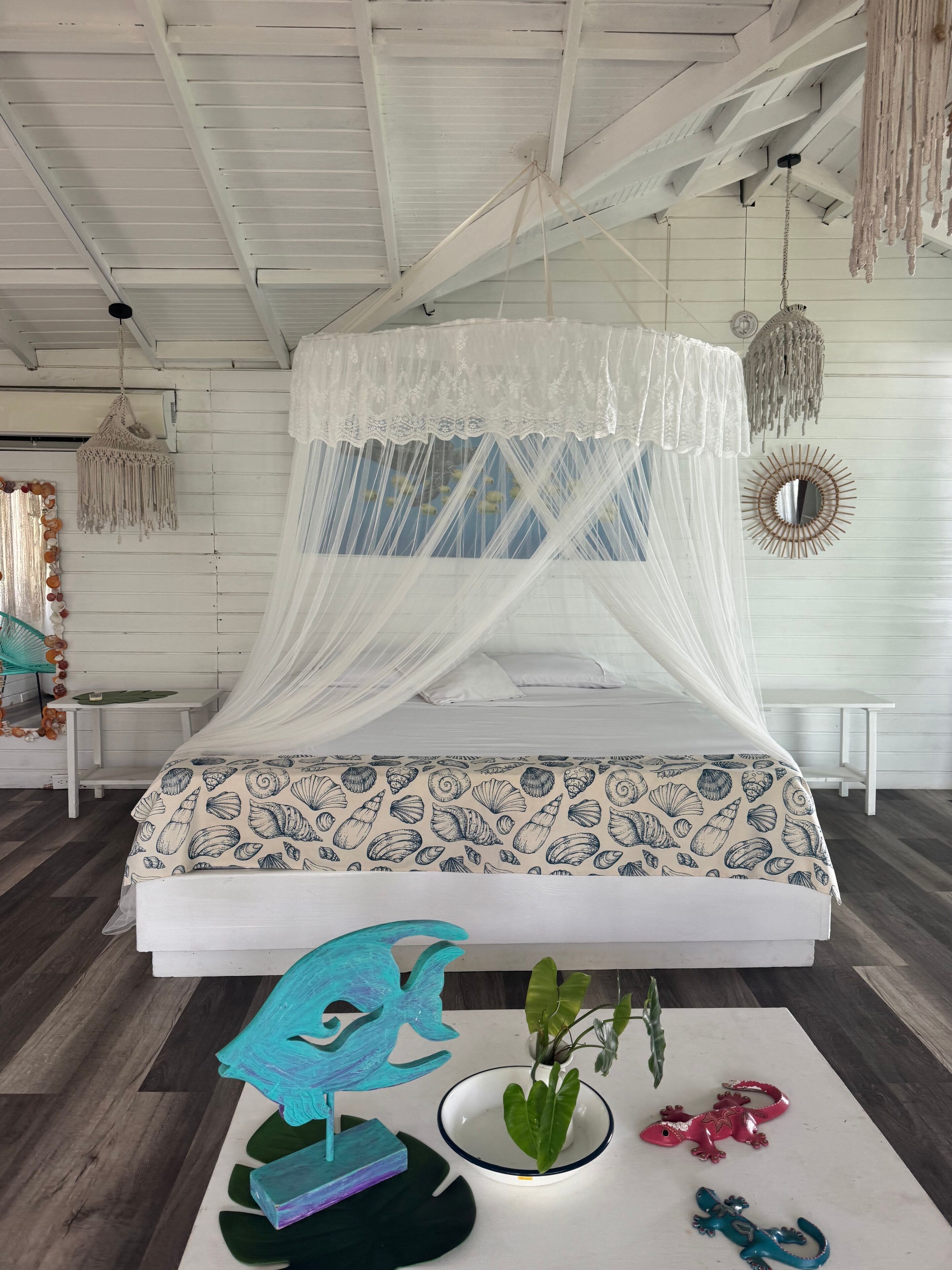 A bed with a white canopy and a seashell patterned bedspread.