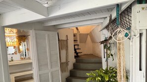 Una escalera que lleva a un segundo piso, con una planta en maceta en el descansillo.
