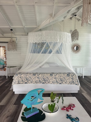A bed with a white canopy and a seashell patterned bedspread. - Siloe Cove Hospedaje Campestre (San Andrés)