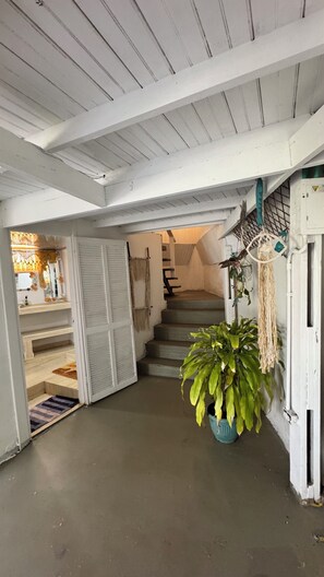Un escalier menant à un deuxième étage, avec une plante en pot sur le palier.