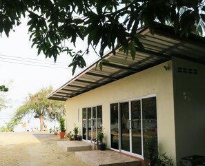 A building with a flat roof, large windows, and a paved entrance area with steps. - Grand Andaman Resort (La-ngu)
