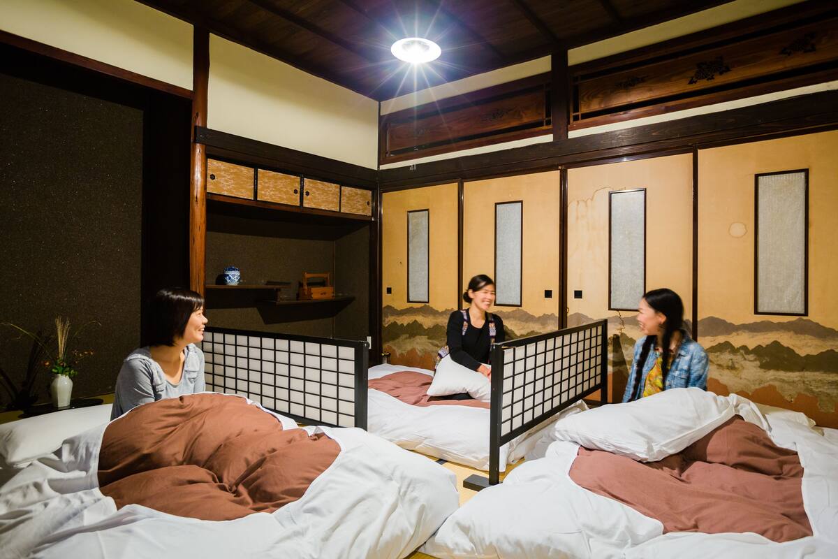 Ein Zimmer mit Etagenbetten, Holzbalken und traditioneller Wandgestaltung.