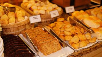 A variety of baked goods displayed on a counter, including bread, pastries, and cookies.