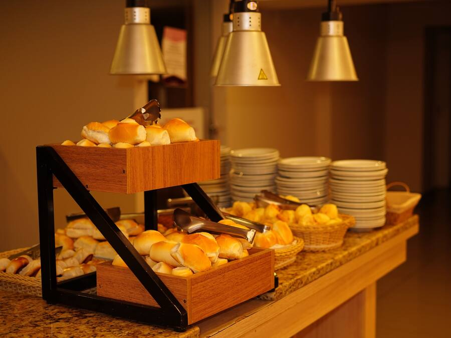 Een buffetopstelling met broodjes en manden vol fruit.