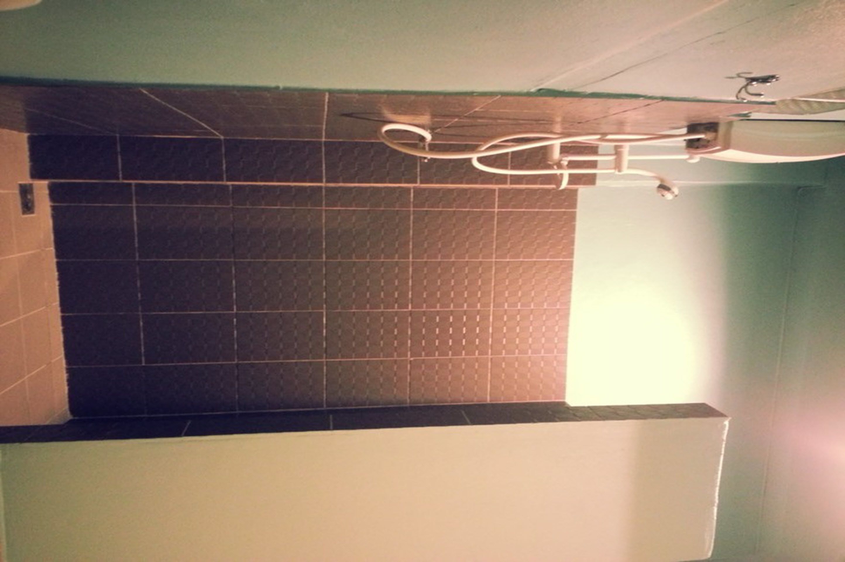 Pared de azulejos con diseño de cuadrícula y un ventilador de techo.