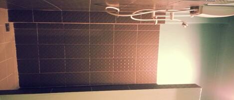 Pared de azulejos con diseño de cuadrícula y un ventilador de techo.