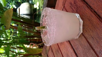 Un verre contenant une boisson glacée, une paille et une garniture décorative, le tout posé sur une surface en bois.